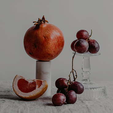 Ein Granatapfel und Weintrauben sind auf Gläsern drapiert – Vital Apotheke Dresden